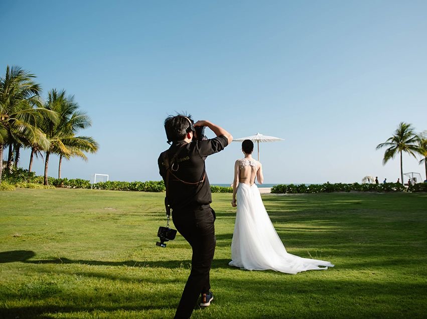 Truong, founder of TIMO Wedding, photographing a bride by the sea in Vietnam