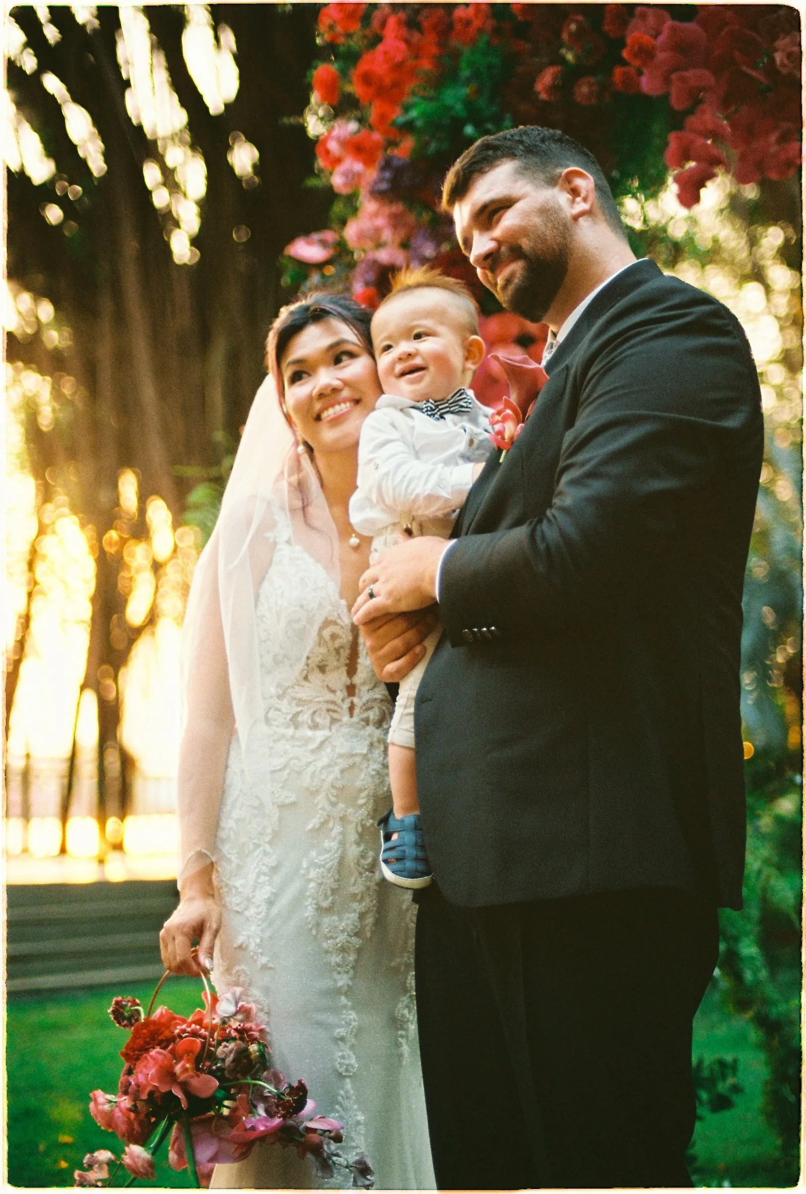 Natasha and Nick with their little one at golden hour, An Lam Retreats on the Saigon River. A film wedding for an international couple in Vietnam.