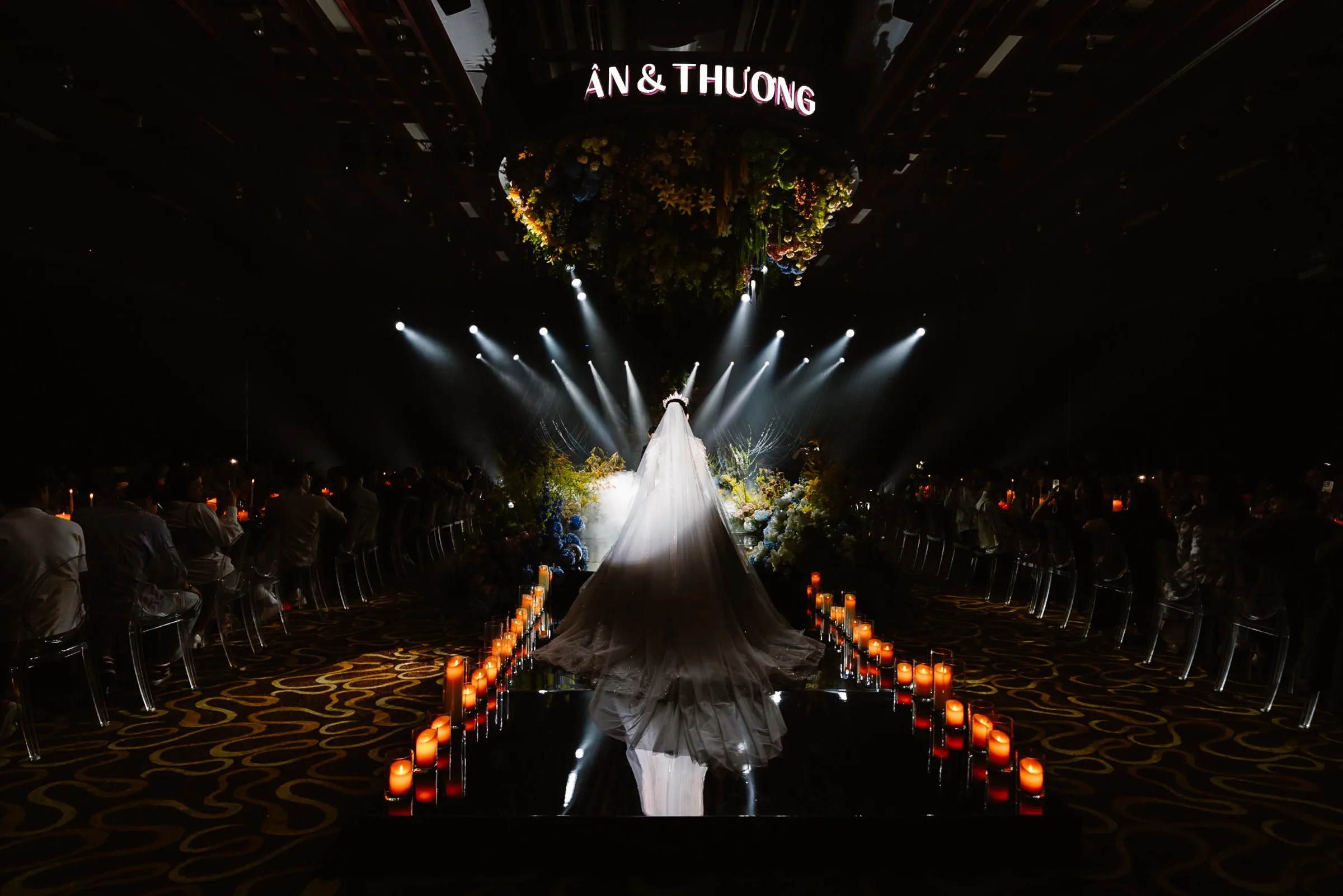Bride walking the candlelit aisle at a luxury Da Nang ballroom wedding