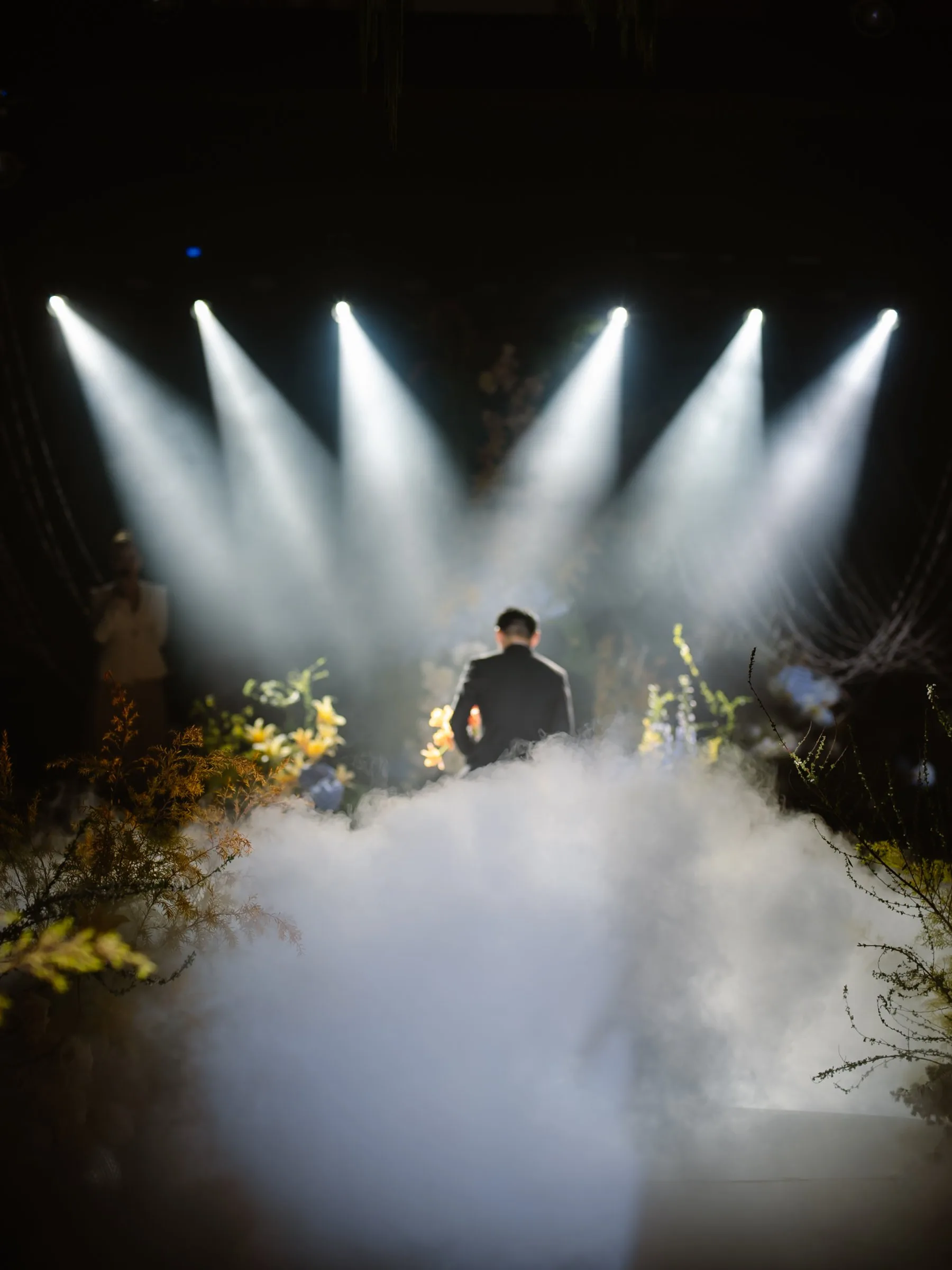 Groom walking into the spotlights and haze at a Da Nang wedding reception