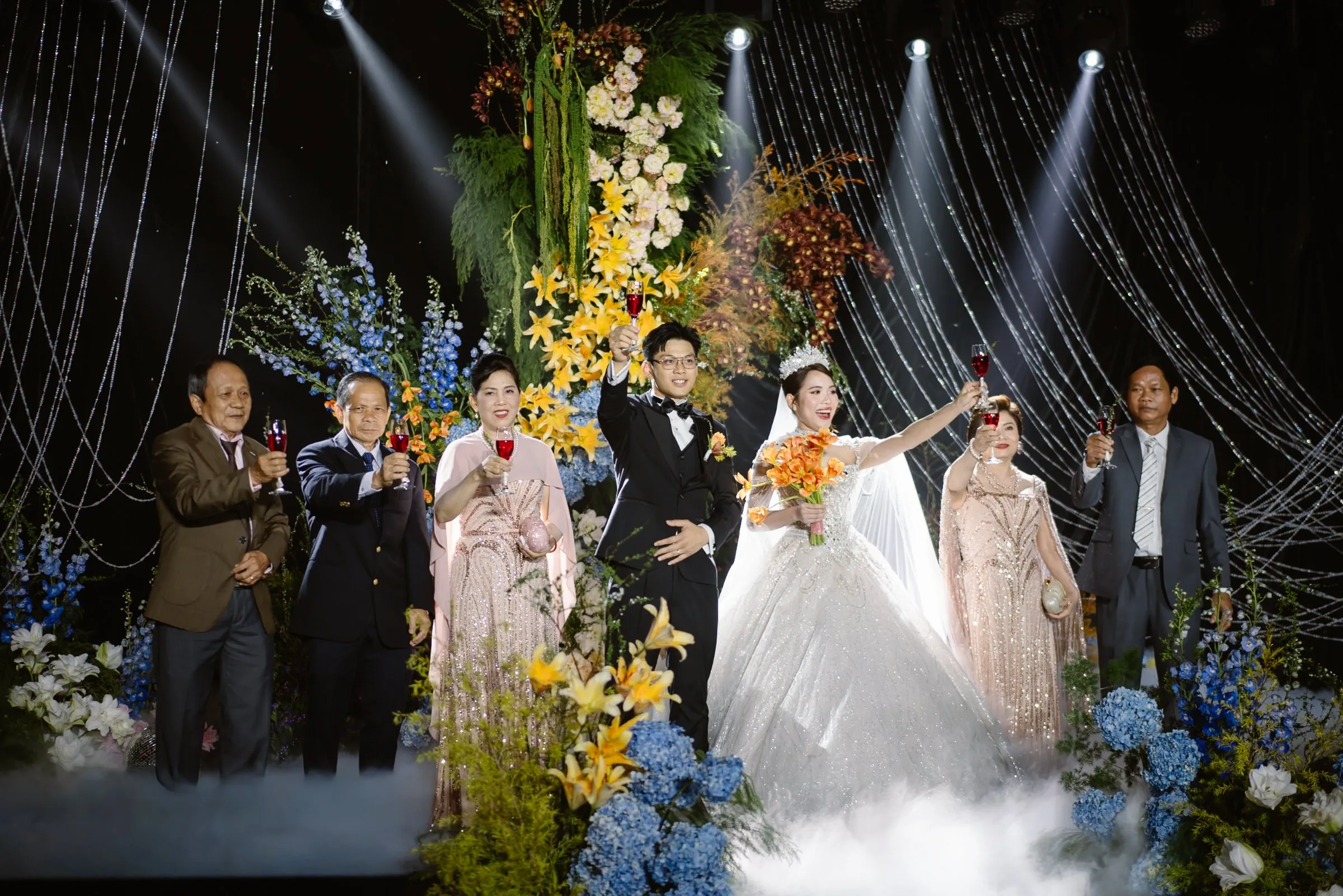 Family toast beneath the flowers at a Da Nang wedding reception