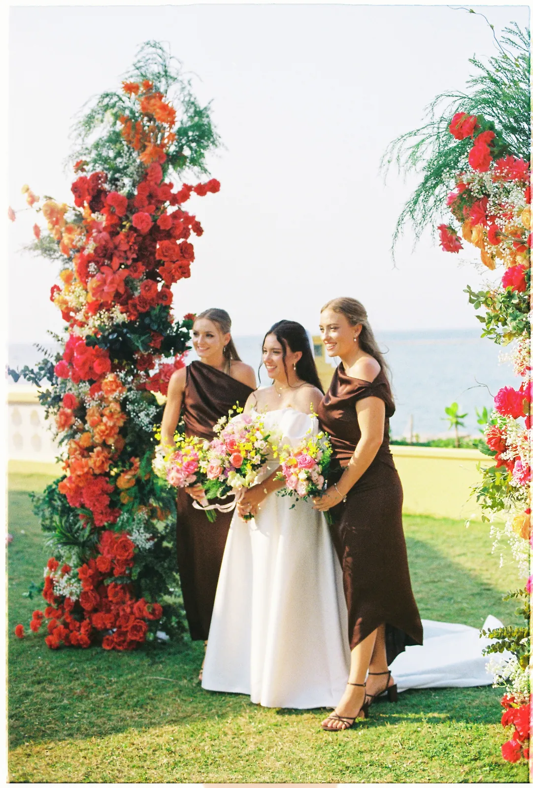 Bride and bridesmaids with bright bouquets at a Hoi An wedding, on film