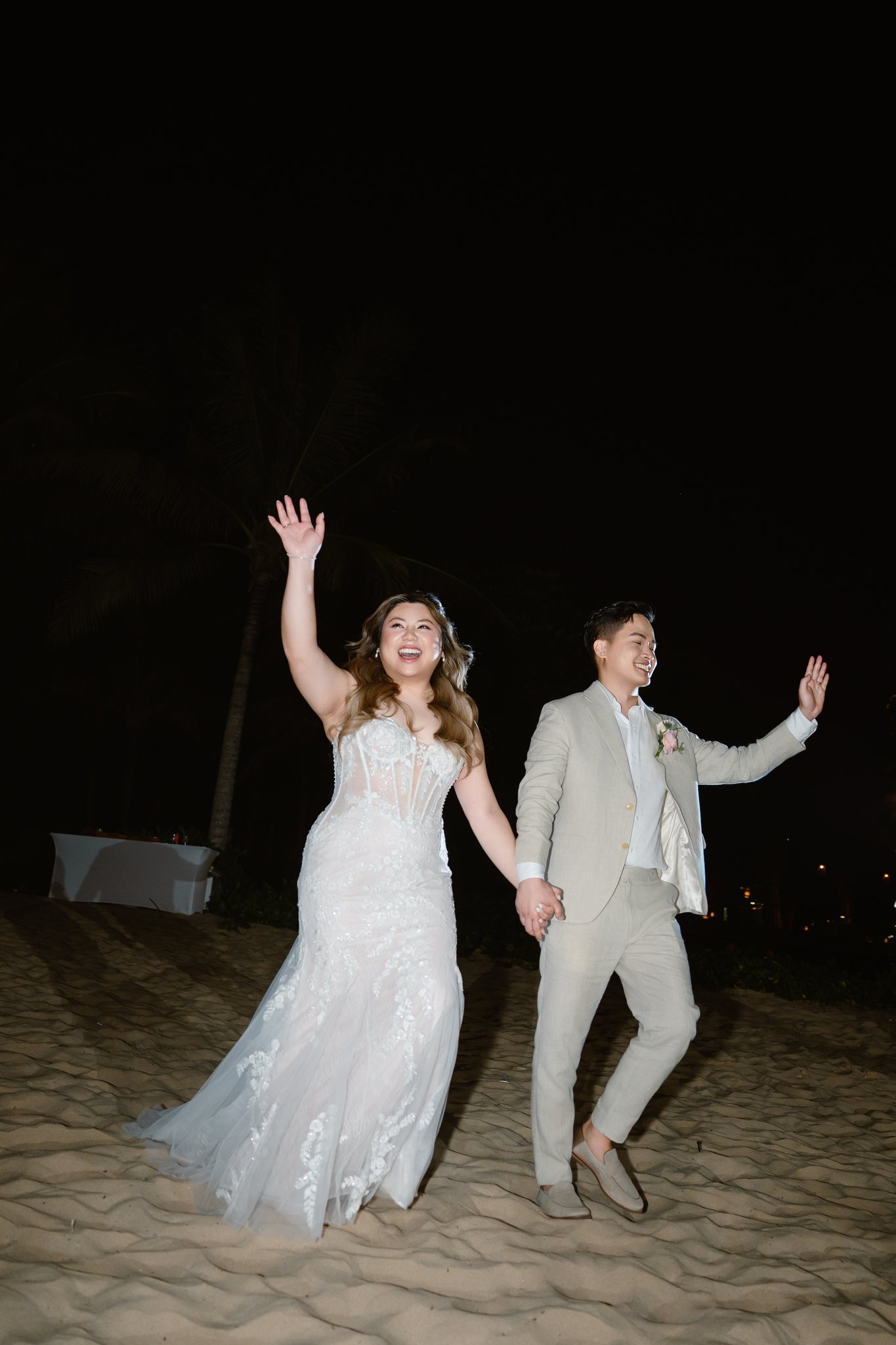 The couple's grand entrance to a fairy-lit beach wedding reception on Phu Quoc
