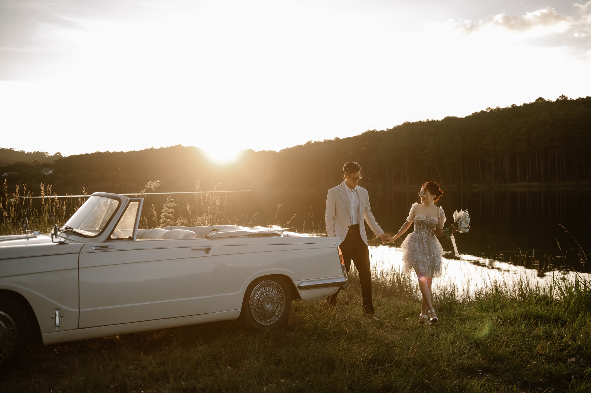 A vintage car by a Da Lat lake at sunset during a pre-wedding