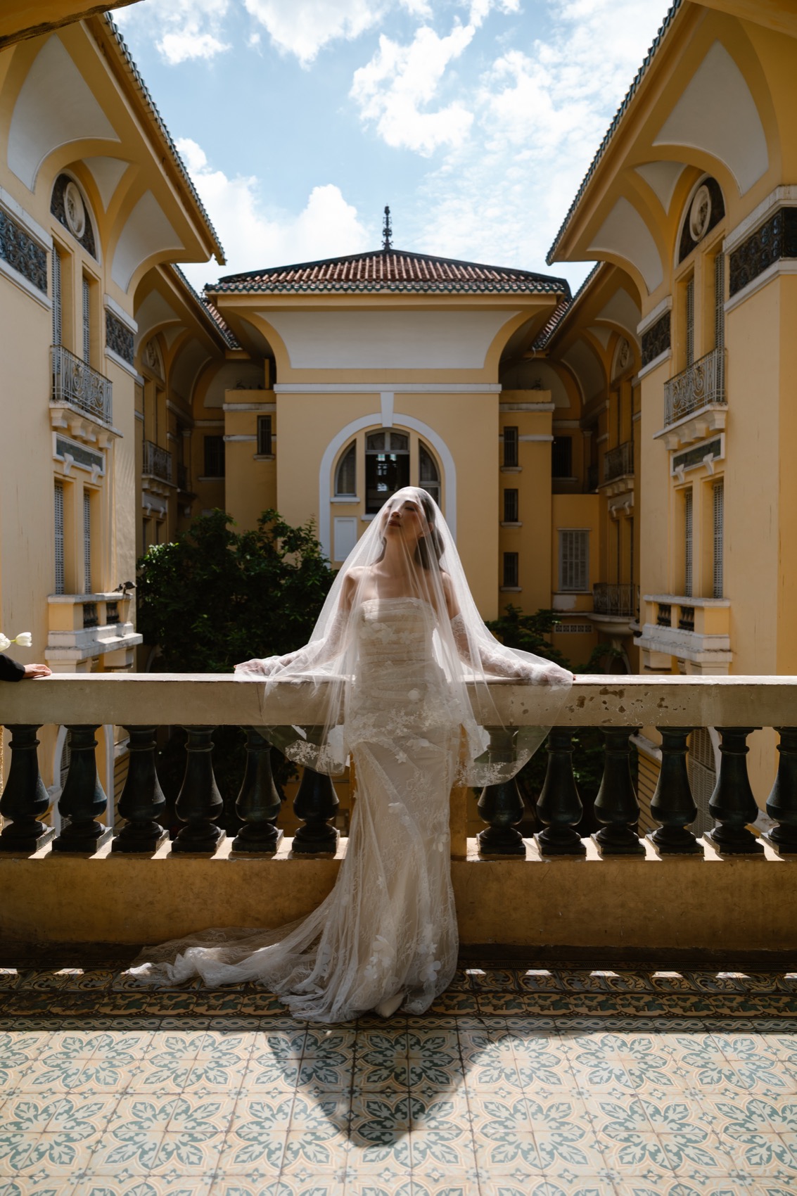 Bride on the balustrade of the Ho Chi Minh City Fine Arts Museum during a Vietnam pre-wedding shoot