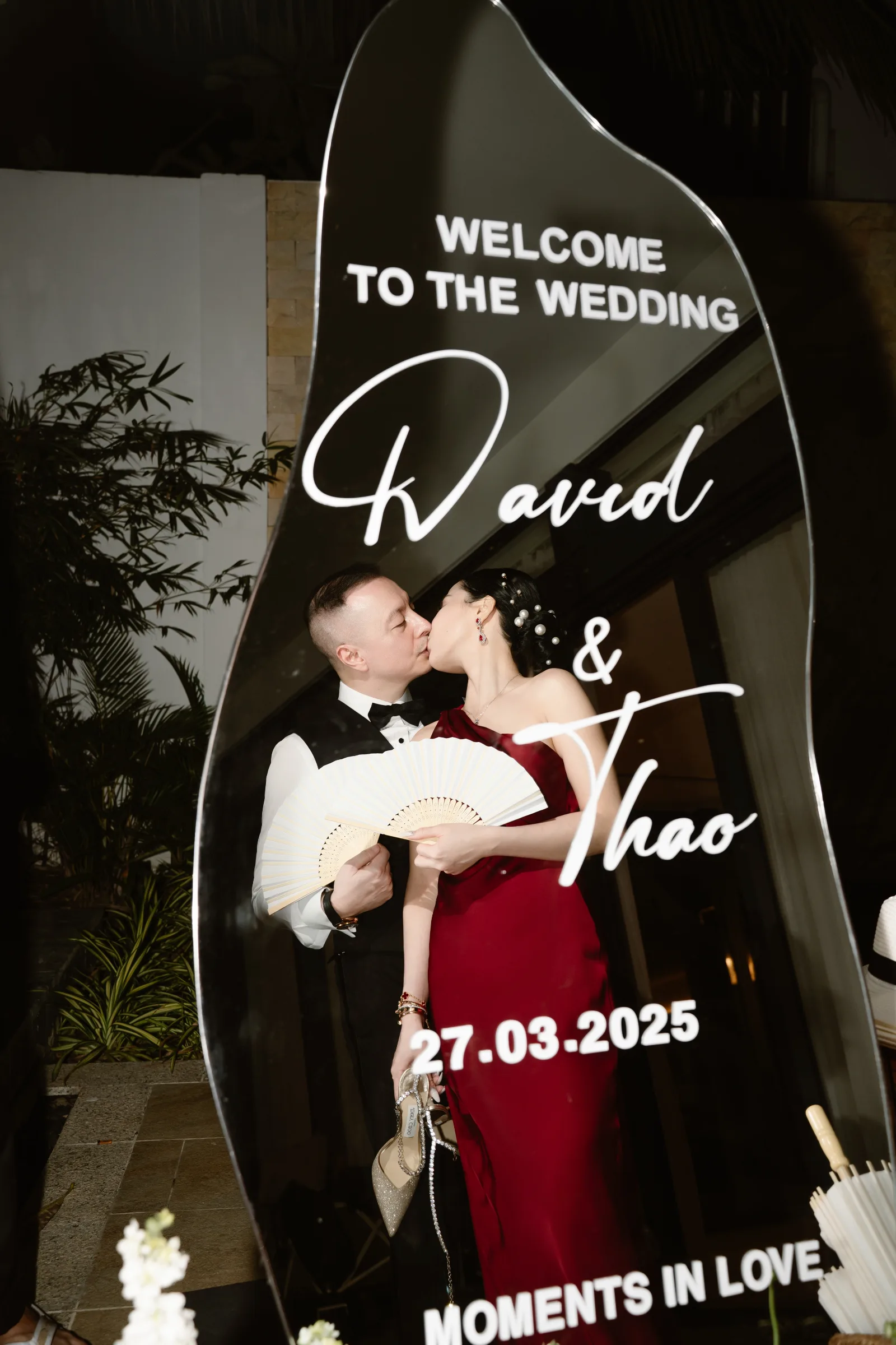 Couple kissing by their welcome sign at a Melia Ho Tram wedding reception